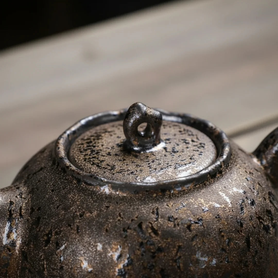 Détail du couvercle d’une théière japonaise en céramique, montrant la glaçure granuleuse et le bouton.