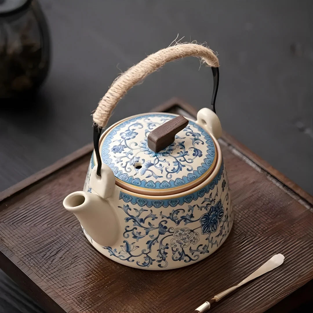 Vue de dessus d’une théière japonaise en céramique bleu et blanc, posée sur un plateau en bois, montrant le couvercle décoré.