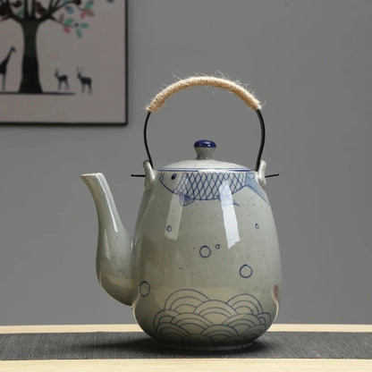 Théière japonaise en céramique avec motif bleu géométrique, posée sur une table sobre.